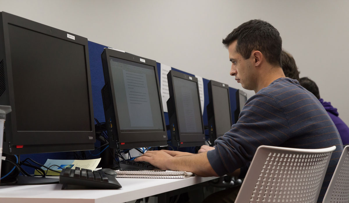 Student using a desktop computer to write